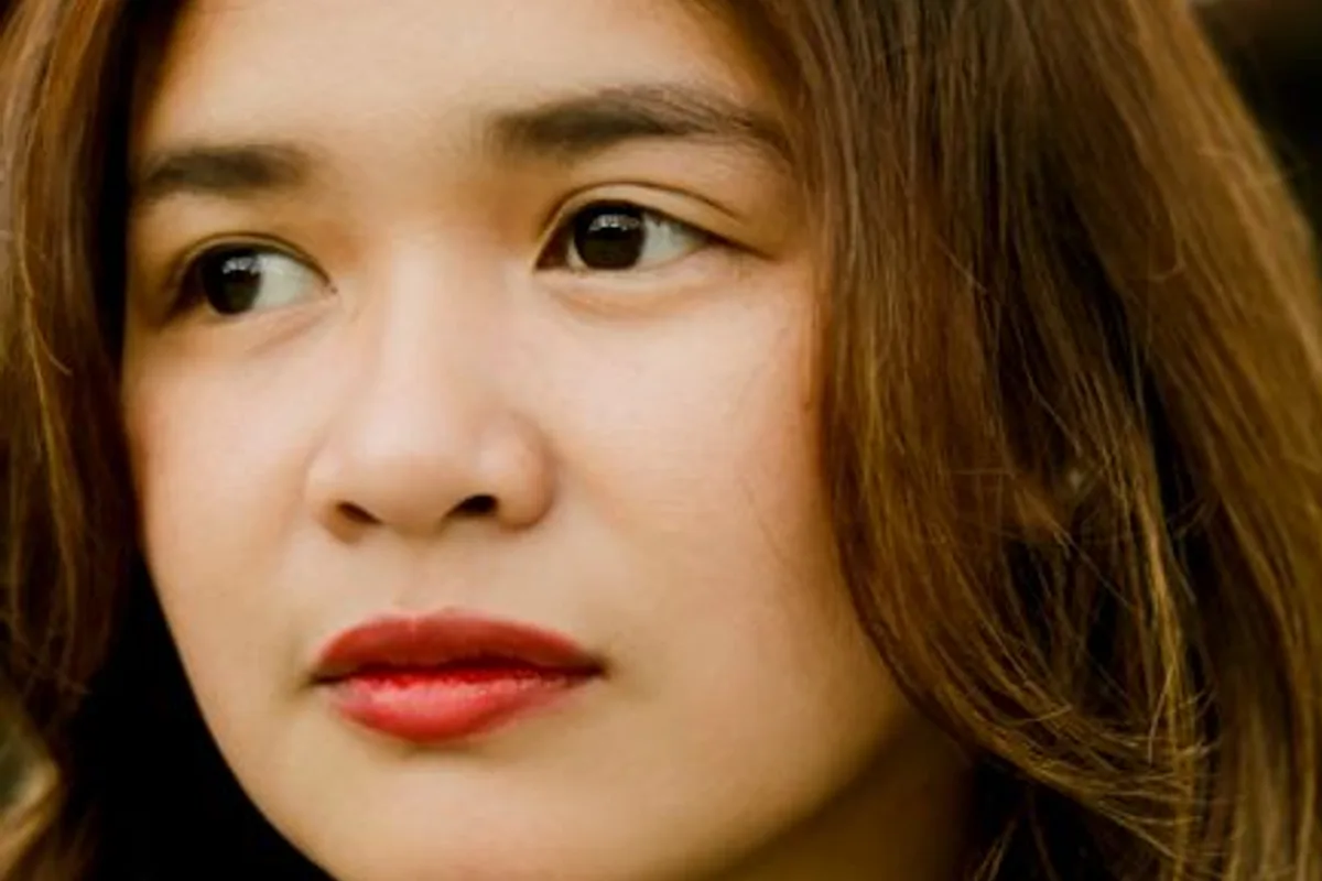 Illustrative image — A portrait of an adult Asian woman with natural skin in a black turtleneck