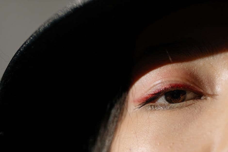Illustrative image — Artistic close-up of an eye with dramatic shadow and minimalistic lighting, creating an intense visual effect.
