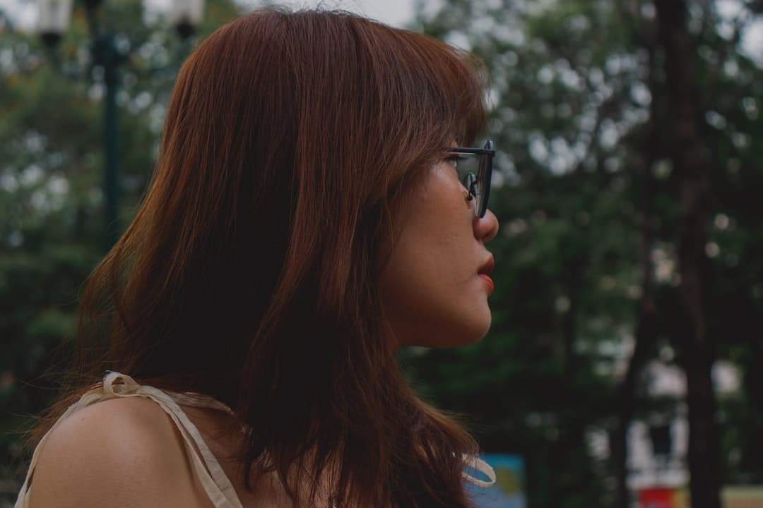 Ảnh minh hoạ — a woman with glasses looking away from the camera