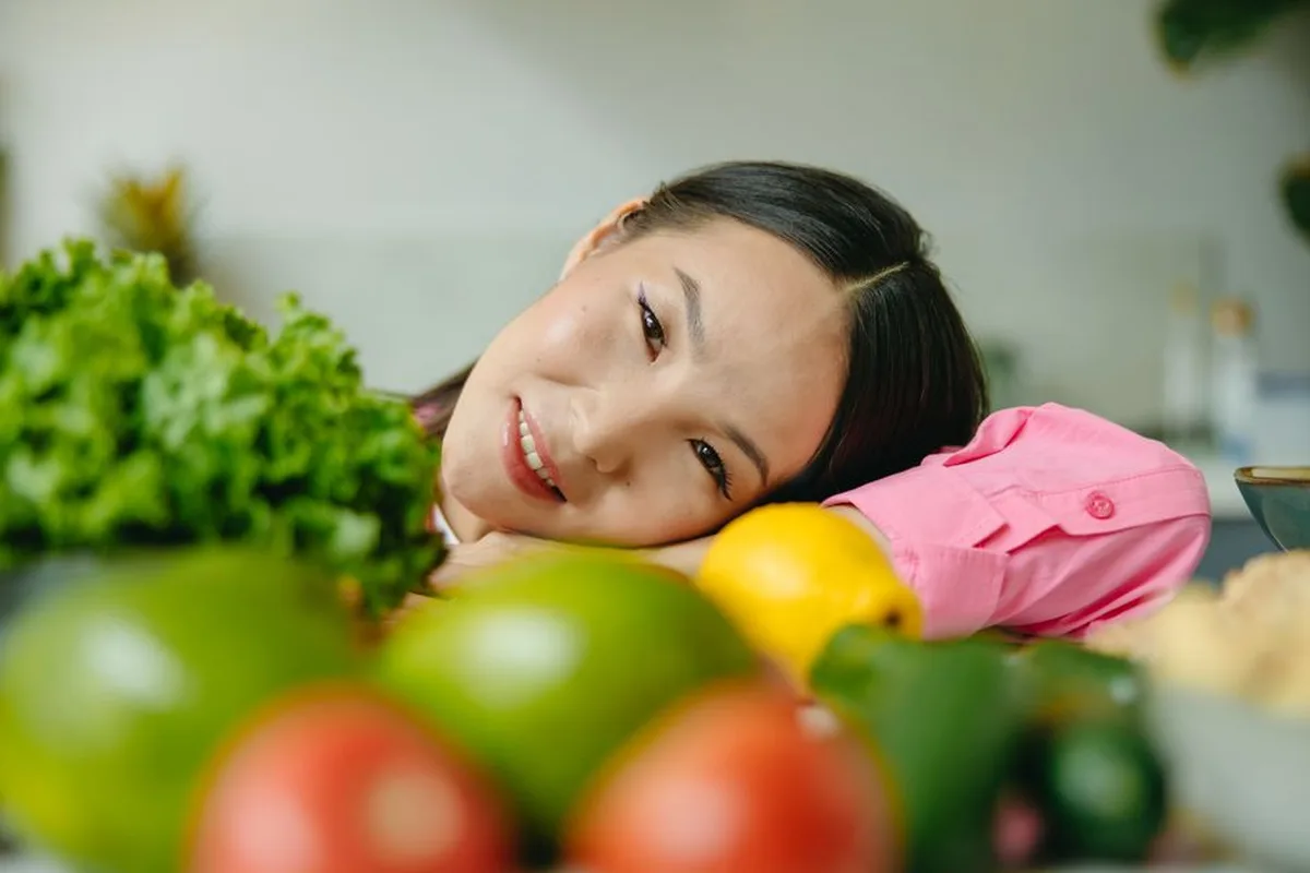 Ảnh minh hoạ — phụ nữ châu Á bên rau củ quả tươi, gợi lối sống lành mạnh