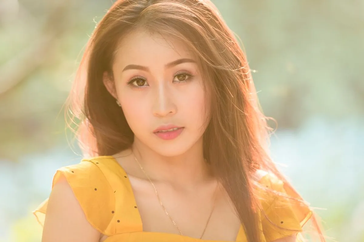 Ảnh minh hoạ — Phụ nữ châu Á gương mặt cân đối rõ nét, nền ngoài trời ấm