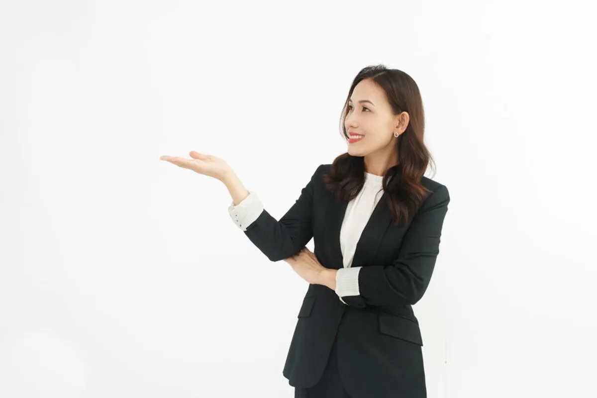 Ảnh minh hoạ — Phụ nữ châu Á mặc vest, tươi cười, gương mặt rõ nét trên nền trắng