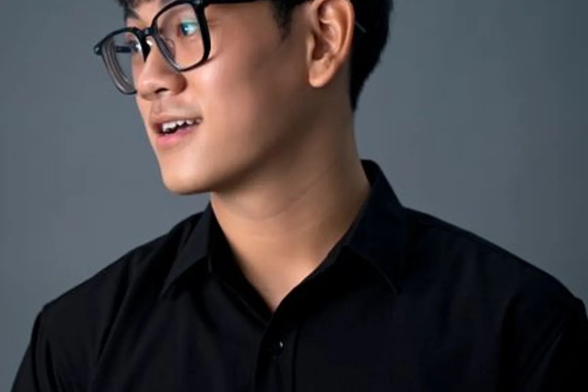 Ảnh minh hoạ — Nam giới châu Á trưởng thành đeo kính, sơ mi đen, nền xám sạch
