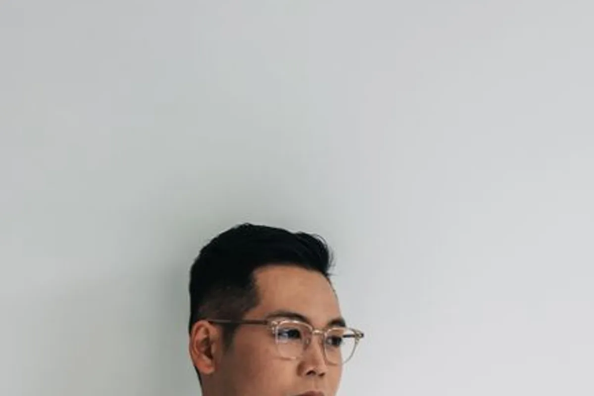 Ảnh minh hoạ — Nam giới châu Á trưởng thành đeo kính, sơ mi trắng lịch sự, nền xám sạch