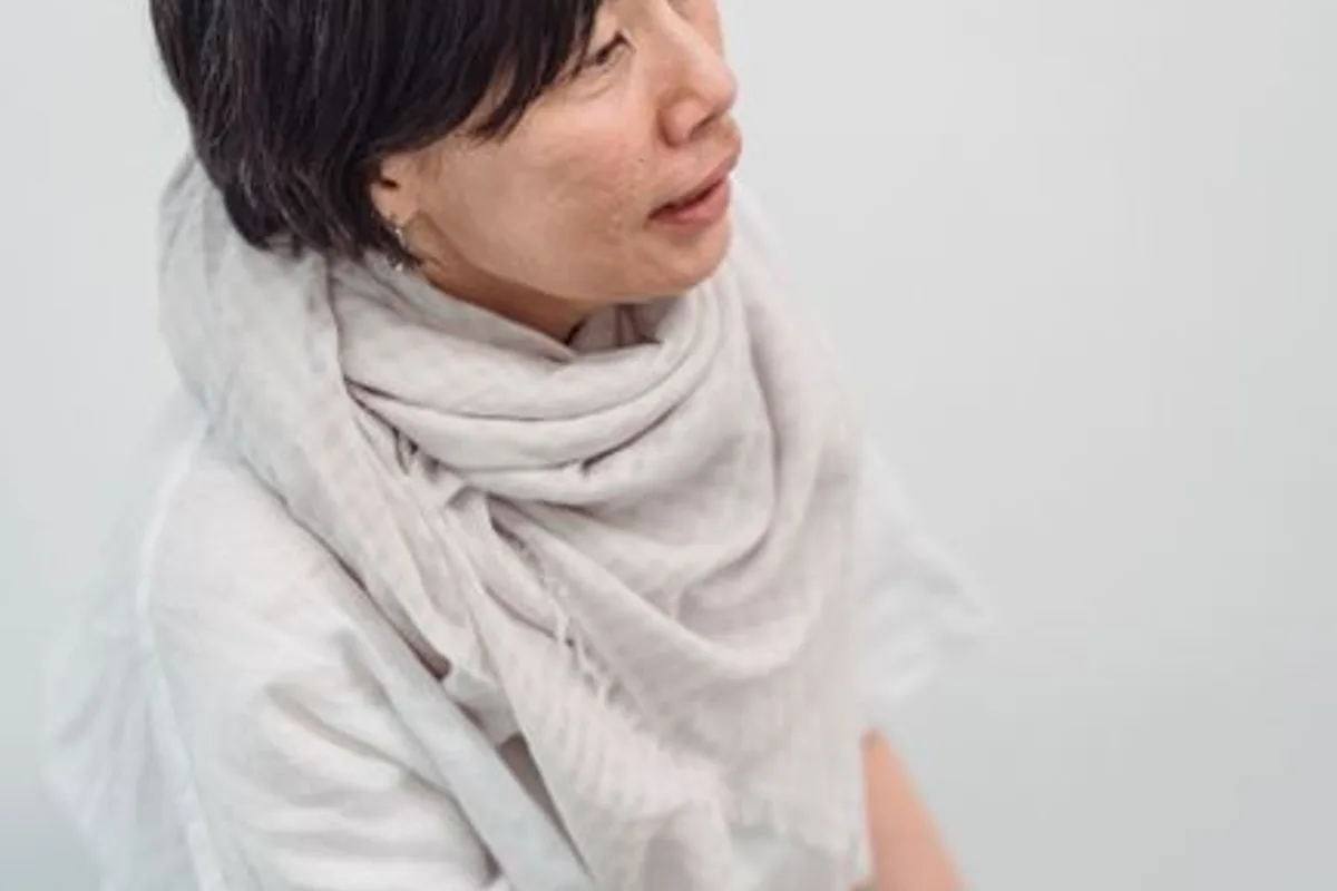 插图 — 围着针织围巾的中年亚洲女性,素颜自然,背景素净