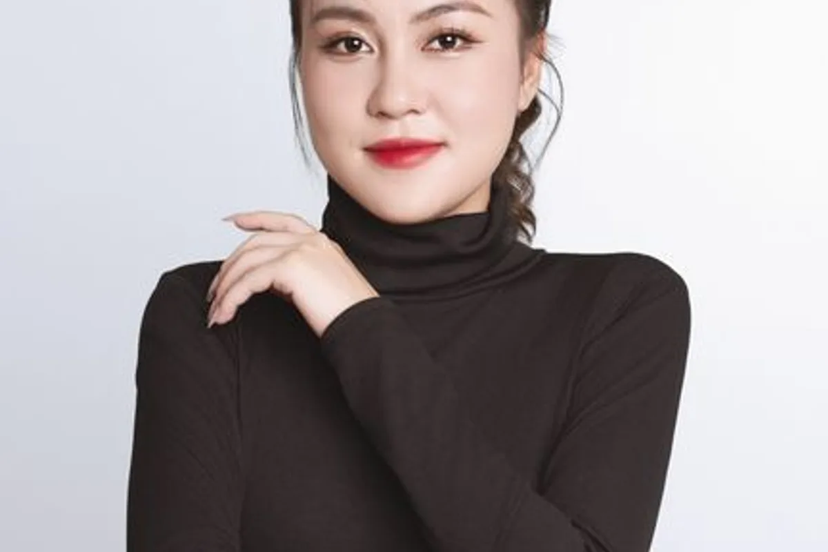 Ảnh minh hoạ — Phụ nữ áo cổ lọ nâu, tì cằm lên tay, làn da mịn, nền sáng