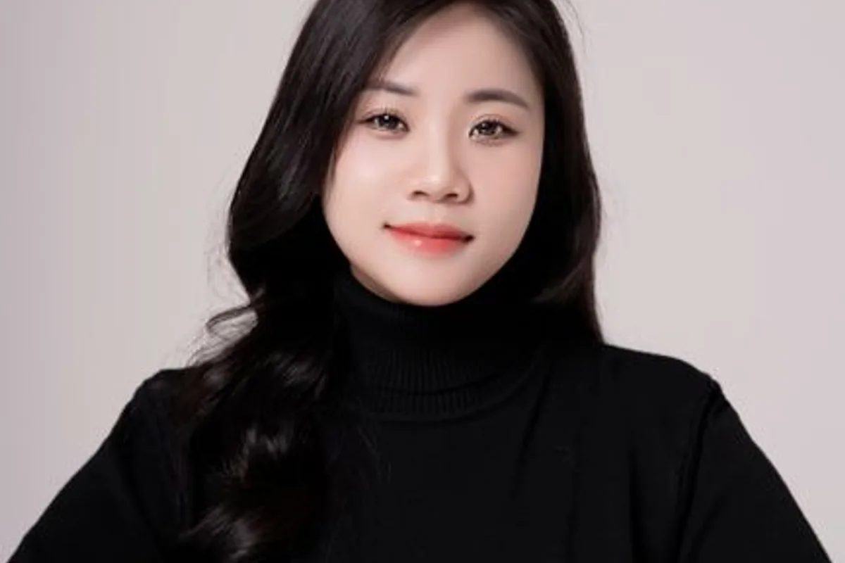 Ảnh minh hoạ — Phụ nữ áo cổ lọ đen, gương mặt điềm tĩnh, làn da đều màu