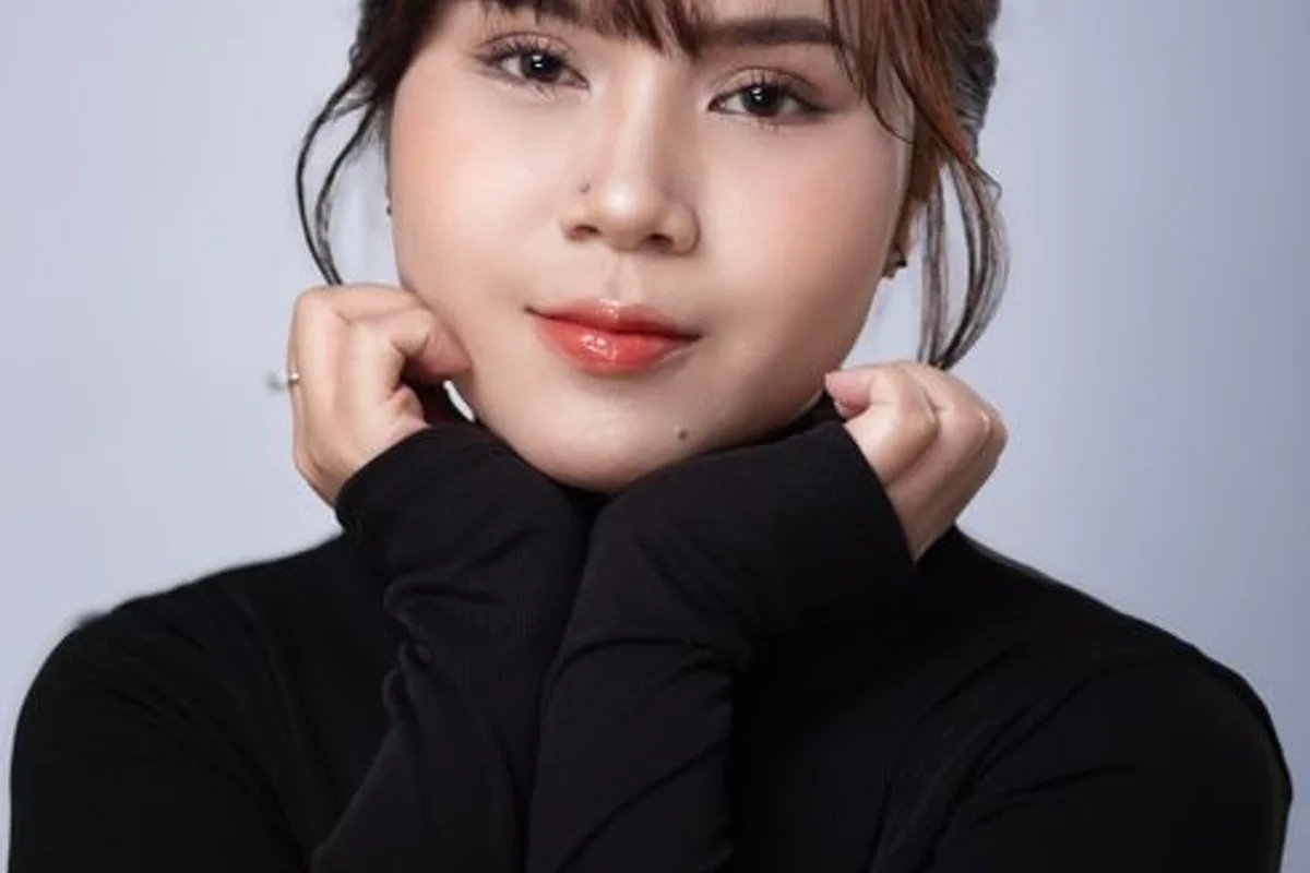 Illustrative image — A woman in a black turtleneck, gently touching her face, smooth skin, studio background