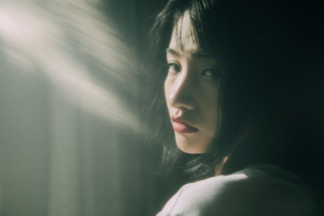 Ảnh minh hoạ — Young woman illuminated by dramatic light beams